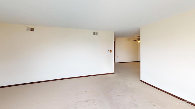 spare room featuring baseboards, visible vents, and carpet floors