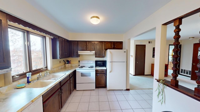 kitchen with dark brown cabinets, white appliances, light tile patterned floors, light countertops, and under cabinet range hood