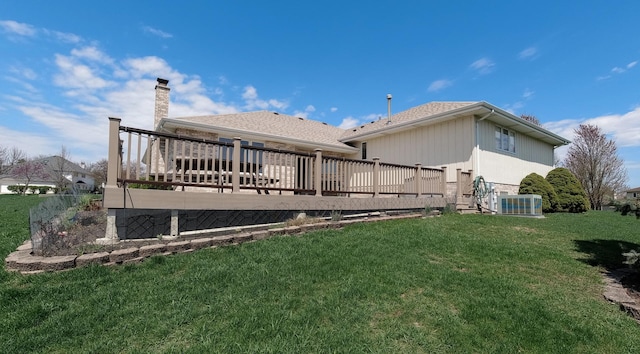 rear view of property with a wooden deck, a chimney, a yard, and cooling unit