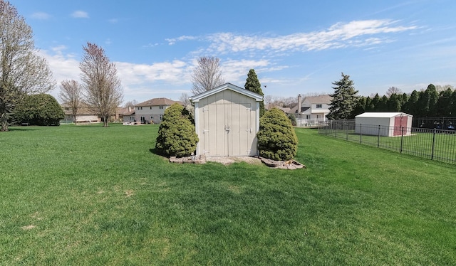 view of yard featuring an outdoor structure, a shed, and fence