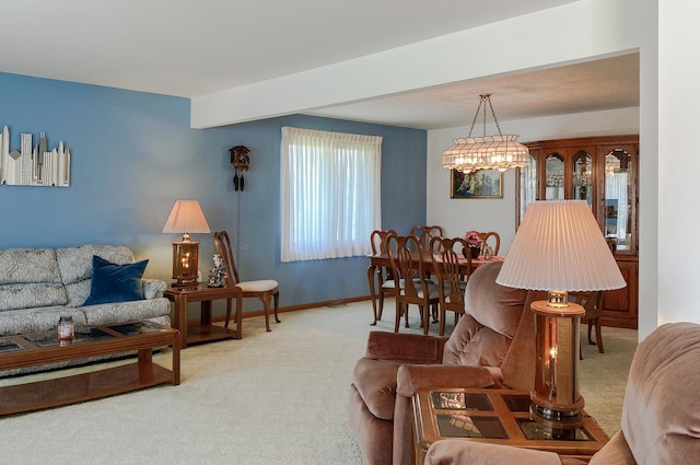 living area with baseboards, an inviting chandelier, and light colored carpet