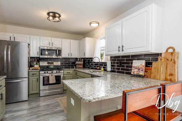 254 Spring Valley Way, Round Lake, IL 60073 - kitchen with stainless steel appliances, backsplash, a sink, a peninsula, and white cabinetry