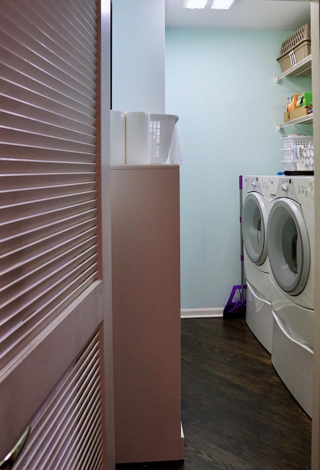 laundry room featuring washing machine and dryer, baseboards, dark wood-style floors, and laundry area
