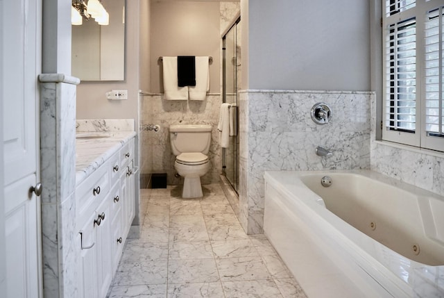 bathroom featuring wainscoting, vanity, tile walls, a jetted tub, and toilet