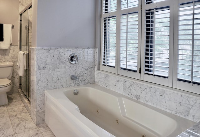 full bath with marble finish floor, toilet, a tub with jets, tile walls, and a stall shower