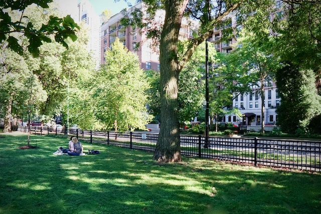 view of community with a yard and fence