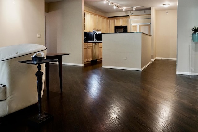 kitchen with a sink, black microwave, light brown cabinetry, dishwasher, and dark wood-style floors