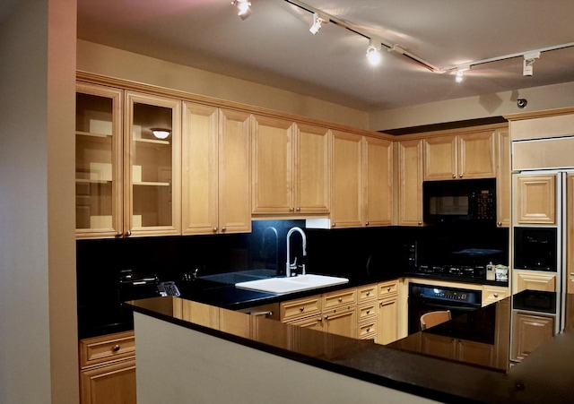 kitchen with dark countertops, light brown cabinetry, a sink, and black appliances