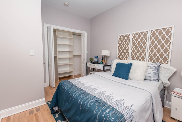 bedroom with visible vents, wood finished floors, and baseboards
