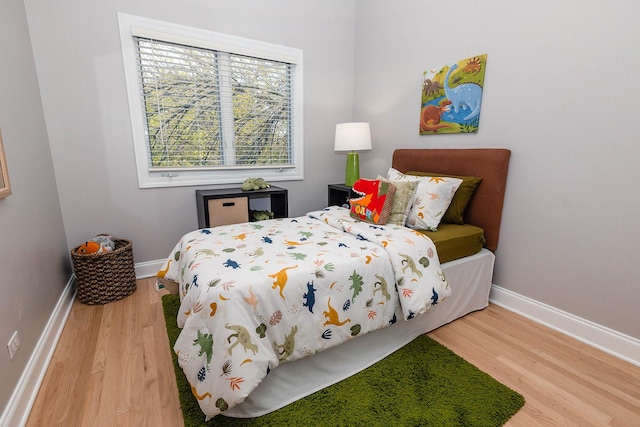 bedroom with baseboards and wood finished floors