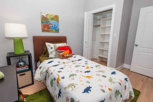 bedroom with baseboards, a closet, and wood finished floors