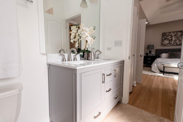 full bath featuring toilet, double vanity, and a sink