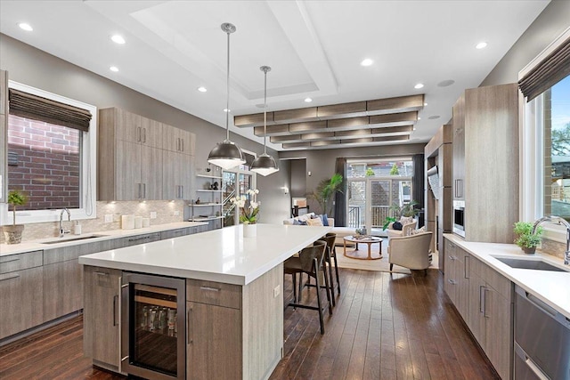 kitchen featuring modern cabinets, a large island, a sink, and wine cooler