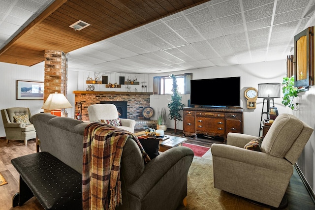 living room featuring visible vents, wood finished floors, and a fireplace