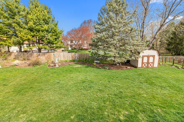 view of yard featuring an outdoor structure, a storage shed, and a fenced backyard