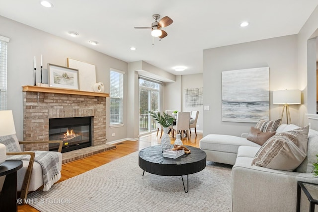 living room with ceiling fan, recessed lighting, wood finished floors, and a fireplace