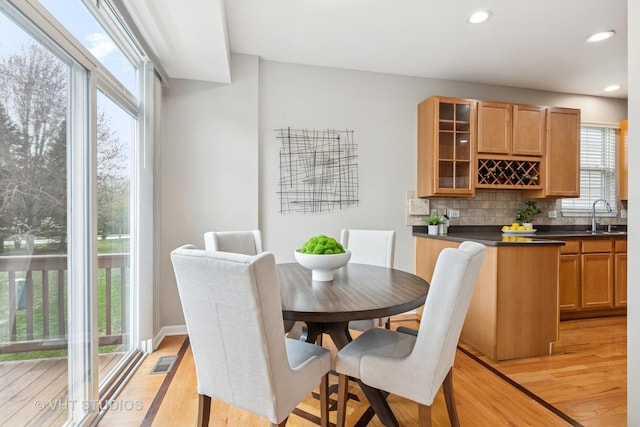 dining space with recessed lighting, light wood-style floors, plenty of natural light, and visible vents