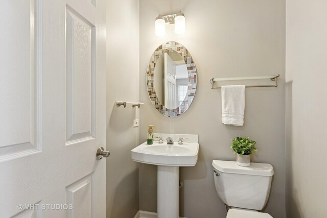 half bathroom with toilet and a sink