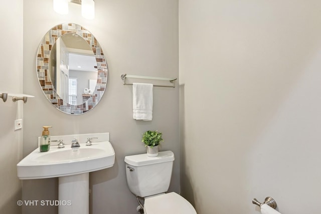 half bathroom with toilet and a sink