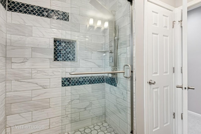 bathroom featuring a shower stall and baseboards