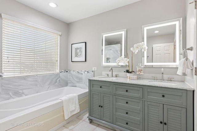 full bath with a bath, tile patterned floors, a sink, and double vanity