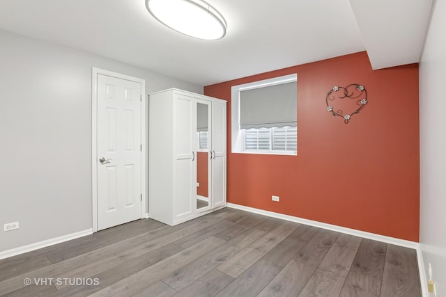 unfurnished bedroom with baseboards and wood finished floors
