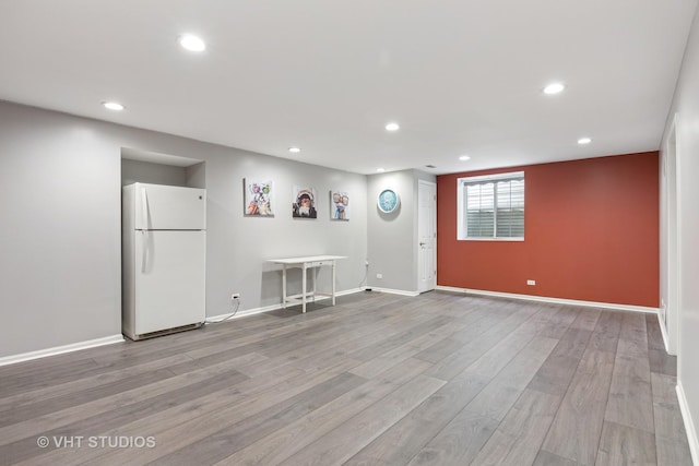 interior space with baseboards, wood finished floors, and recessed lighting
