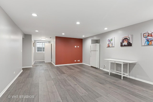 spare room with wood finished floors, baseboards, and recessed lighting