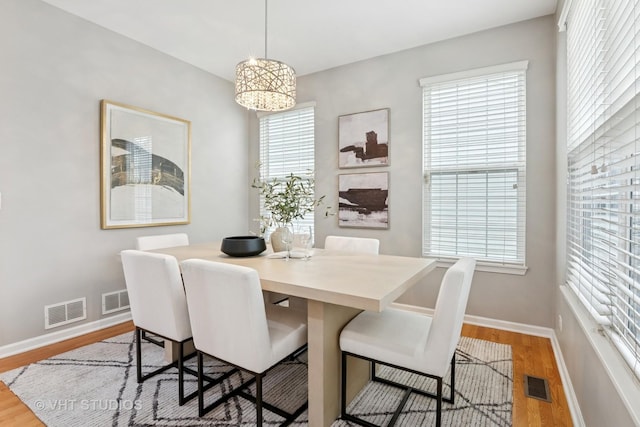 dining area with a wealth of natural light, visible vents, and light wood-type flooring