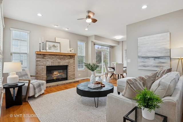 living room with wood finished floors, a fireplace, recessed lighting, and ceiling fan