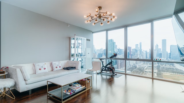 living area featuring wood finished floors, a chandelier, a view of skyline, and a wall of windows