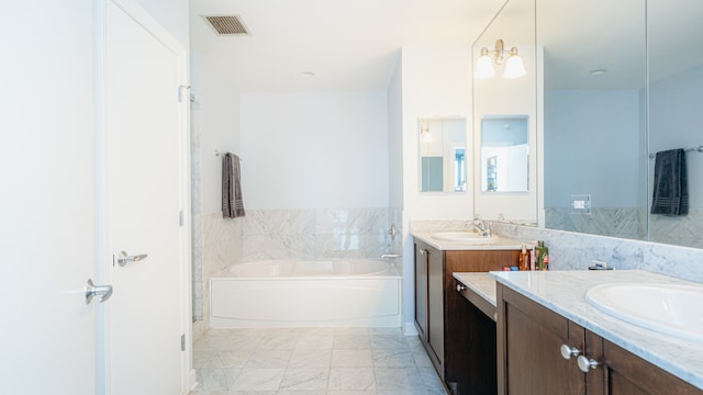 full bathroom with a garden tub, marble look tile flooring, and two vanities