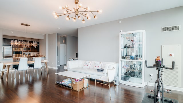 living room featuring a chandelier, dark wood-type flooring, and baseboards