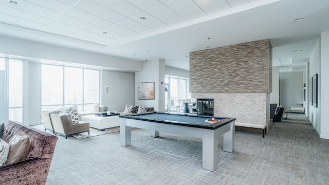 playroom with light carpet, a tile fireplace, and pool table