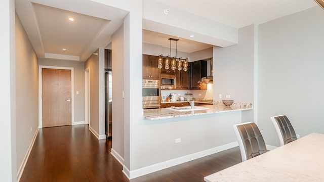 kitchen featuring dark wood-type flooring, built in microwave, double oven, light stone countertops, and recessed lighting