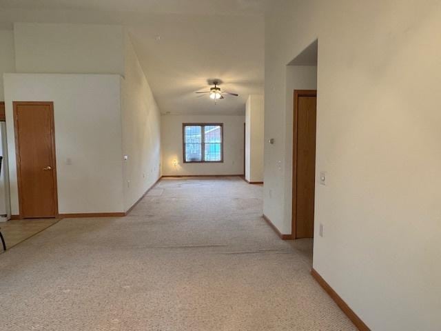 unfurnished room with light carpet, a ceiling fan, and baseboards