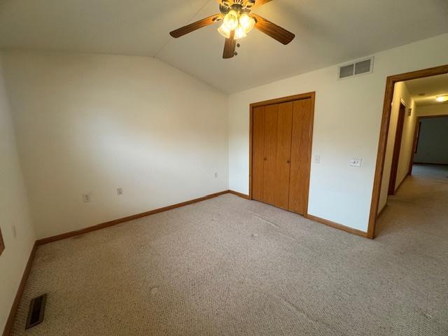 unfurnished bedroom featuring light colored carpet, baseboards, and visible vents