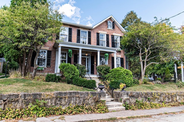 105 S High St, Galena, IL 61036 - view of front of property featuring covered porch, brick siding, and a front yard