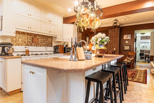 105 S High St, Galena, IL 61036 - kitchen with tasteful backsplash, a breakfast bar, light countertops, white cabinetry, and a kitchen island