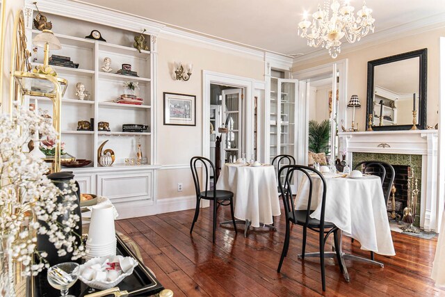 105 S High St, Galena, IL 61036 - dining space featuring dark wood finished floors, baseboards, an inviting chandelier, a fireplace, and ornamental molding