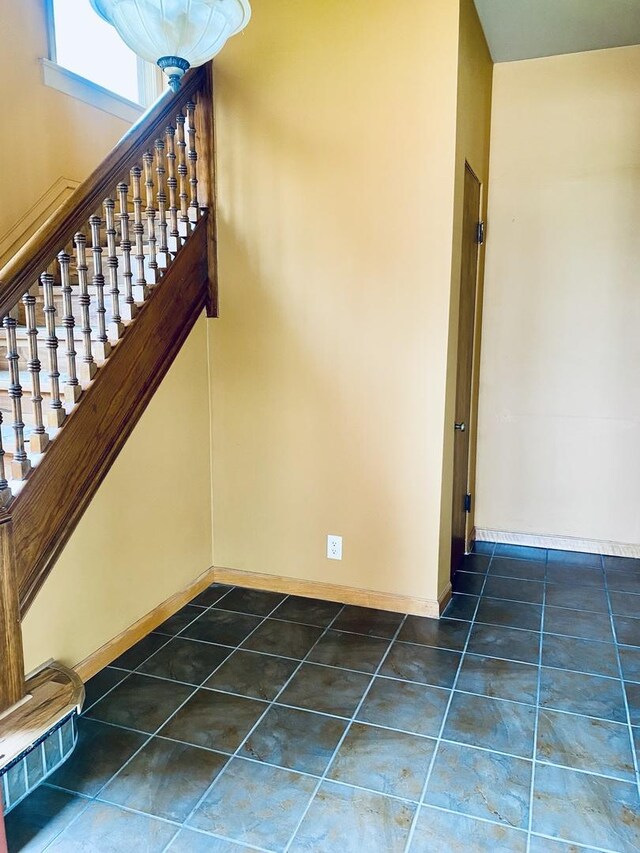 stairway with tile patterned flooring and baseboards
