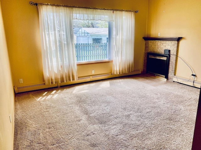 unfurnished living room featuring carpet flooring, a brick fireplace, baseboards, baseboard heating, and a baseboard radiator