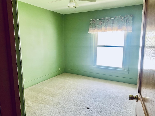 carpeted empty room with a ceiling fan