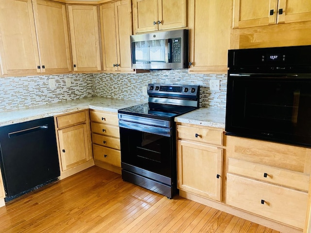kitchen with black appliances, light brown cabinetry, backsplash, and light wood-type flooring
