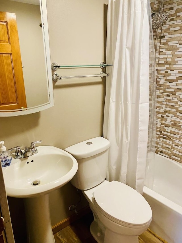 bathroom featuring shower / bath combo with shower curtain and toilet