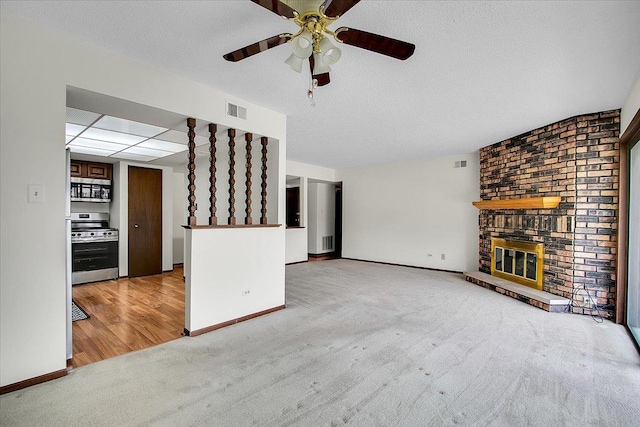 9178 S Rd E Unit D, Palos Hills, IL 60465 - unfurnished living room featuring light colored carpet, ceiling fan, a brick fireplace, and a textured ceiling