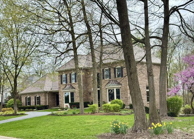 view of front facade featuring brick siding and a front lawn