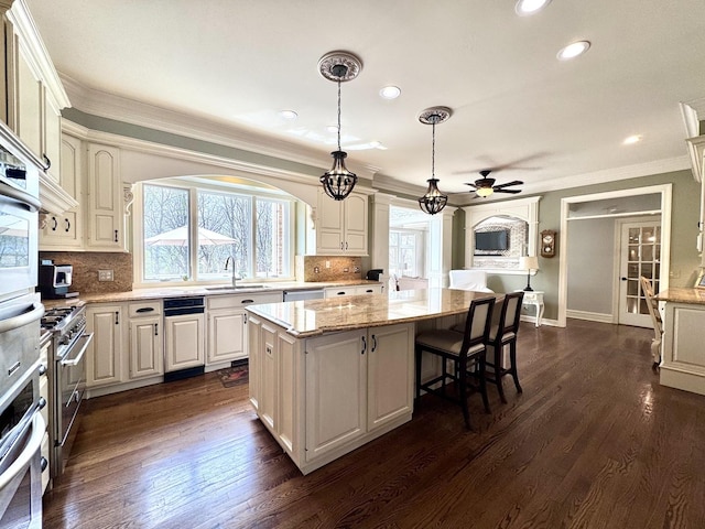 kitchen with a kitchen island, ceiling fan, recessed lighting, a sink, and dark wood finished floors