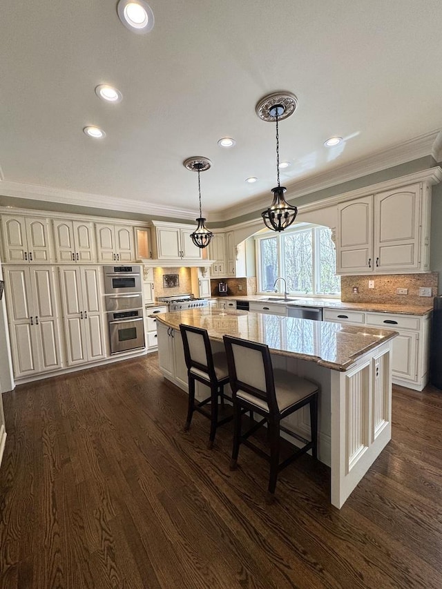 kitchen featuring crown molding, a center island, stainless steel appliances, and dark wood-style floors