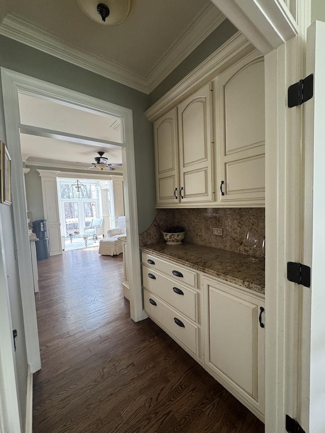 bar with decorative backsplash, ceiling fan, dark wood-style floors, and ornamental molding
